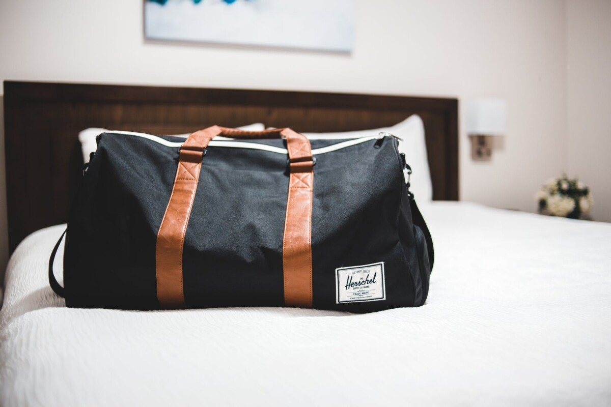 modern sports bag on bed in hotel room