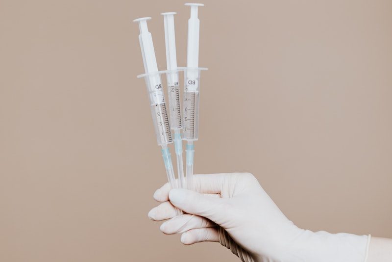 Person Holding Three Syringes with Medicine